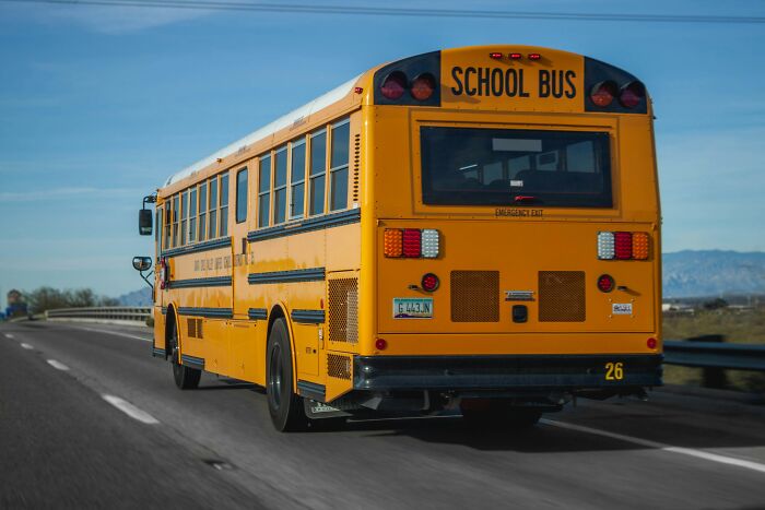 Yellow school bus driving on highway, symbolizing fast life changes and people who completely ruined their lives quickly.