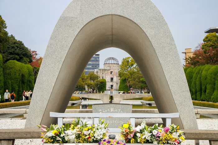 Peace Memorial Arch with flowers and distant ruins, symbolizing reflection on shocking family secrets revealed.