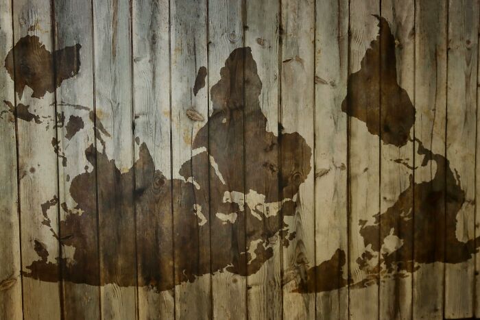 Upside-down map of the world on rustic wooden planks for geography fans and country naming challenge.