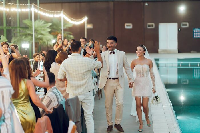 Newlyweds celebrating with guests by the pool, capturing a moment in the lives of people who were the villain in someone else’s story.