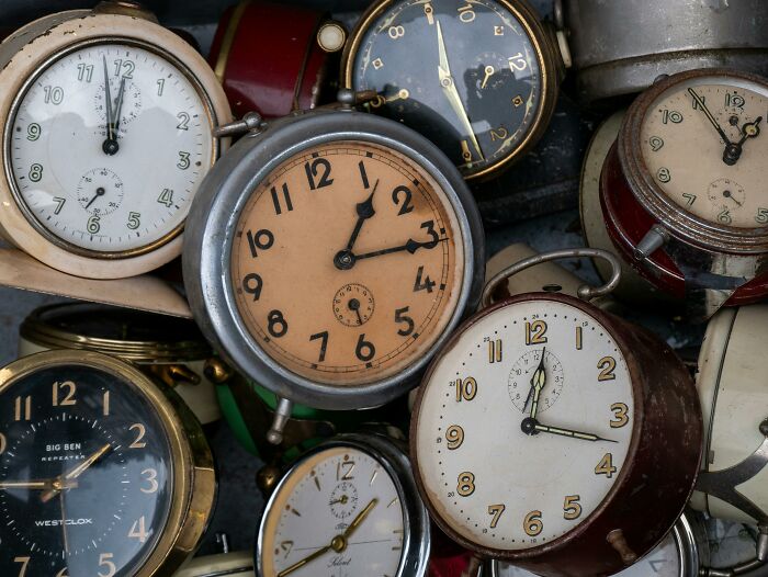 Several vintage alarm clocks clustered together, symbolizing people share sounds extremely angry in a noisy setting.