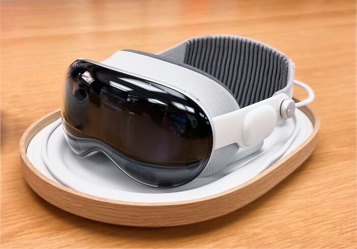VR headset with padded strap placed on a wooden table, representing the next big thing that totally flopped in tech.