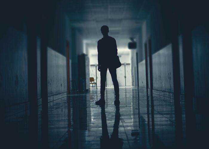 Silhouetted figure standing in a dark corridor, evoking the eerie atmosphere of terrifying true stories beneath our feet.