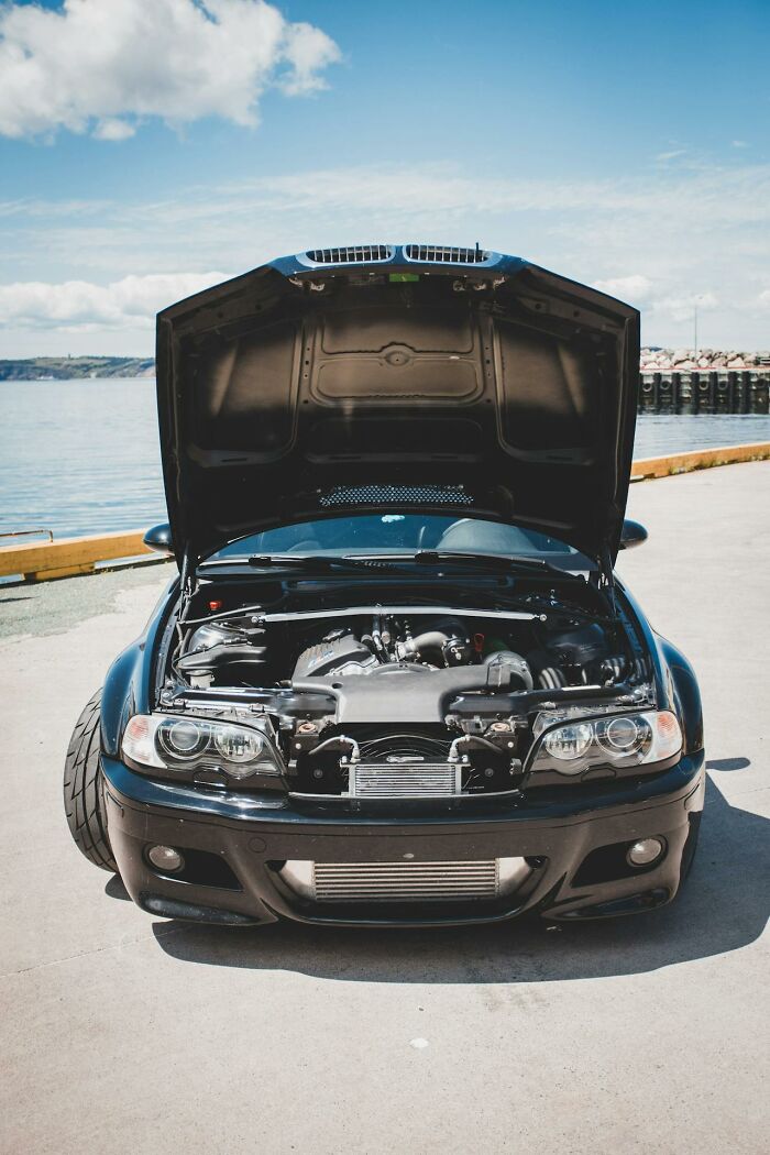Black car with hood open and engine exposed on a sunny day, symbolizing terrifying moments people thought were their last.