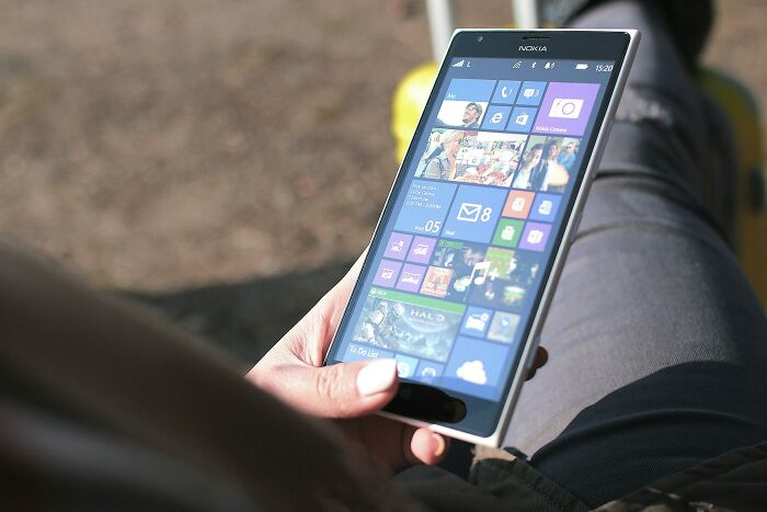 Person holding a Nokia smartphone outdoors displaying a tiled interface, illustrating the next big thing that totally flopped concept.