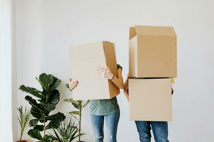 Two people holding cardboard boxes, illustrating the impact of losing all their savings from a single event.
