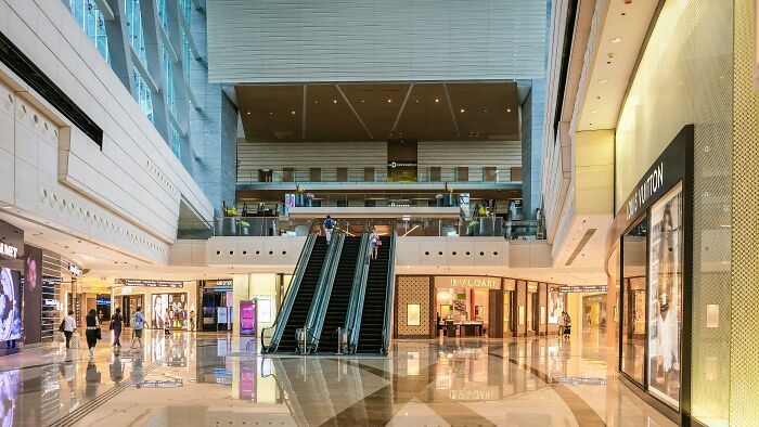 Interior of an abandoned department store with escalators and empty walkways, site of ancient skeletons discovery by archaeologists.