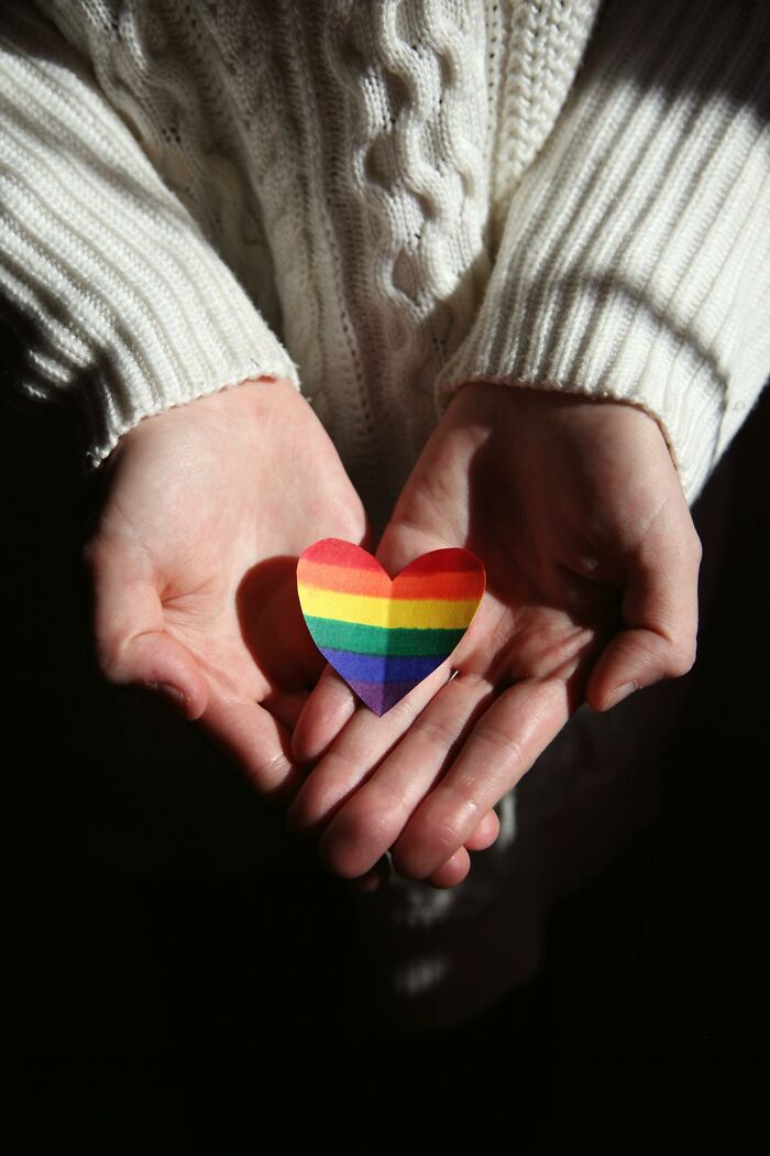 Hands holding a rainbow heart paper cutout symbolizing unbelievable things that were actually true in a hopeful setting.
