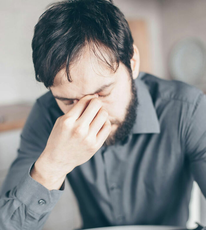 Man in gray shirt pinching bridge of nose, showing disbelief in response to unbelievable things that were true.
