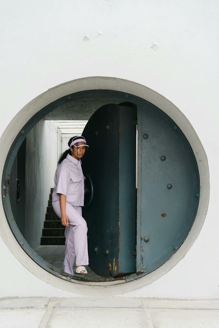 Woman in lavender outfit standing in a large circular vault door, representing jobs for ultra-wealthy people.