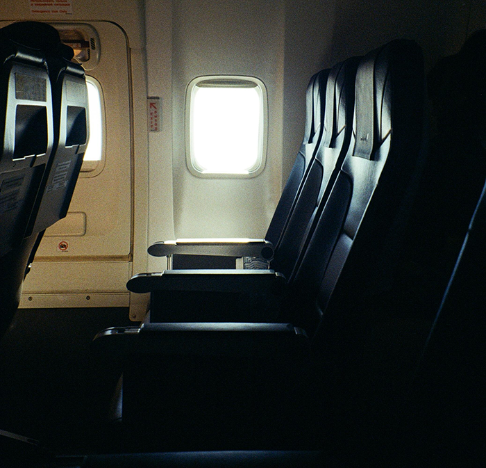 Airplane seats with a window view, illustrating the topic of buying two seats for comfort on flight for an obese passenger.