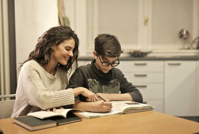 A woman with a sweet facade helping a boy with homework, illustrating hidden manipulation and betrayal in real life.