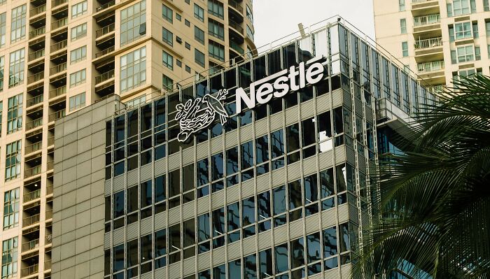 Nestle logo on a glass office building facade, illustrating popular overhyped products people often stop buying.
