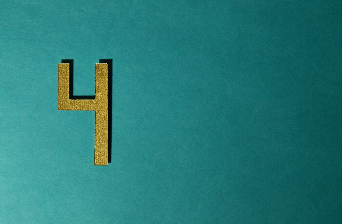 Gold number four on a teal background representing a digital puzzle in the guess words mystery game.