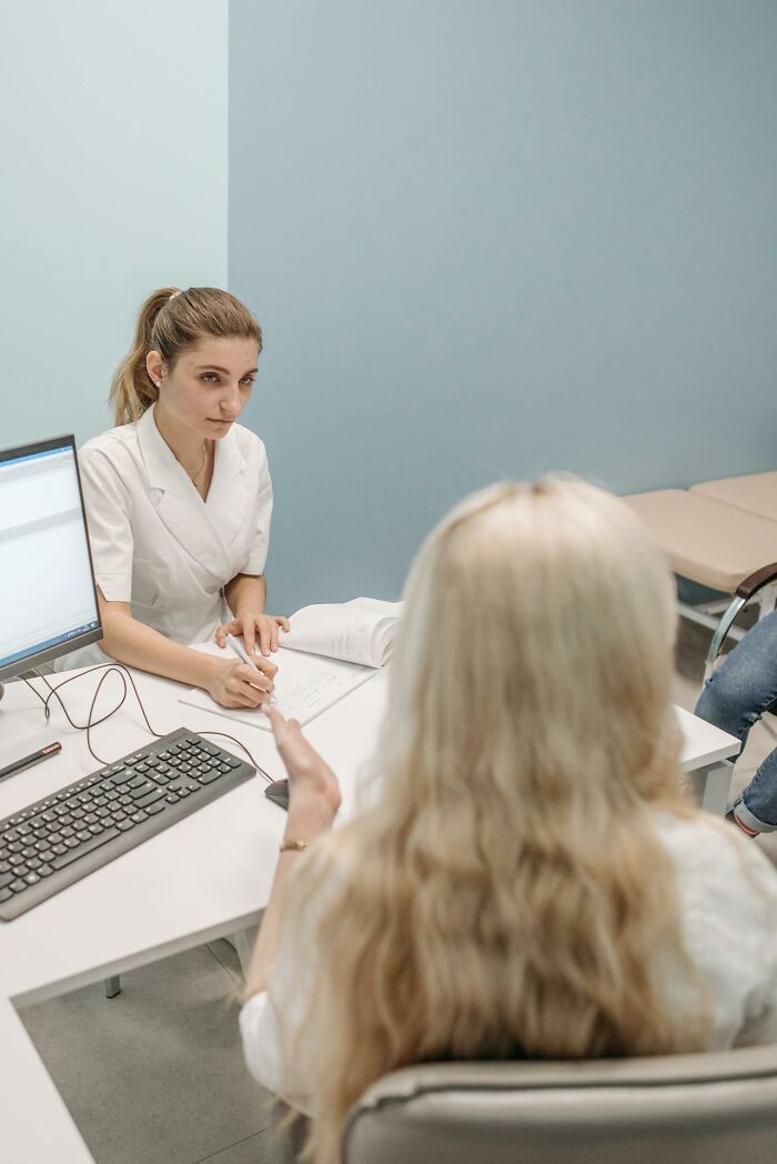 Female doctor consulting woman at office desk, highlighting differences in things women are not allowed to do versus men.