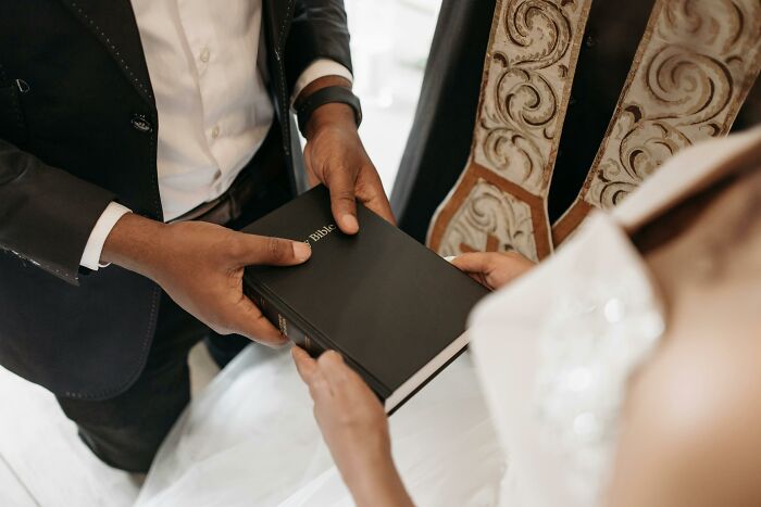 Couple exchanging a black Bible, symbolizing secret stories and hidden truths in relationships found online.