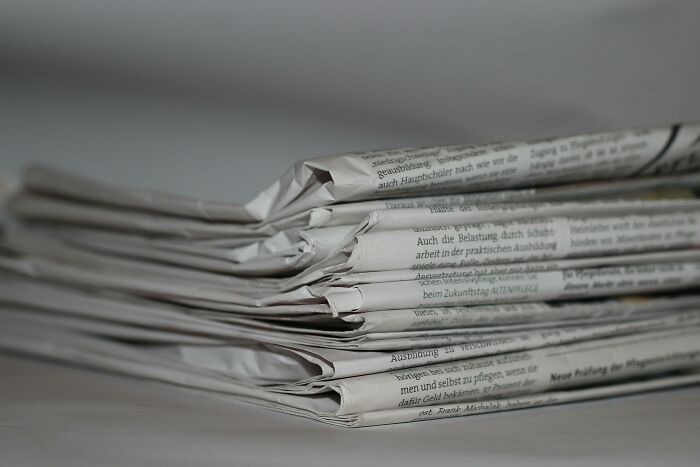 Stack of folded newspapers representing unexplained mysteries from the dawn of the internet still puzzling people today
