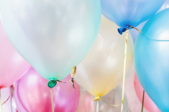 Colorful balloons with shiny ribbons, illustrating popular overhyped products people say everyone should stop buying.