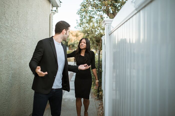 Man and woman having a tense conversation in a narrow outdoor path, showing signs a relationship isn’t going to last.