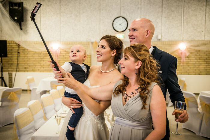 A group of people at a wedding taking a selfie, illustrating men who married out of pressure life updates.