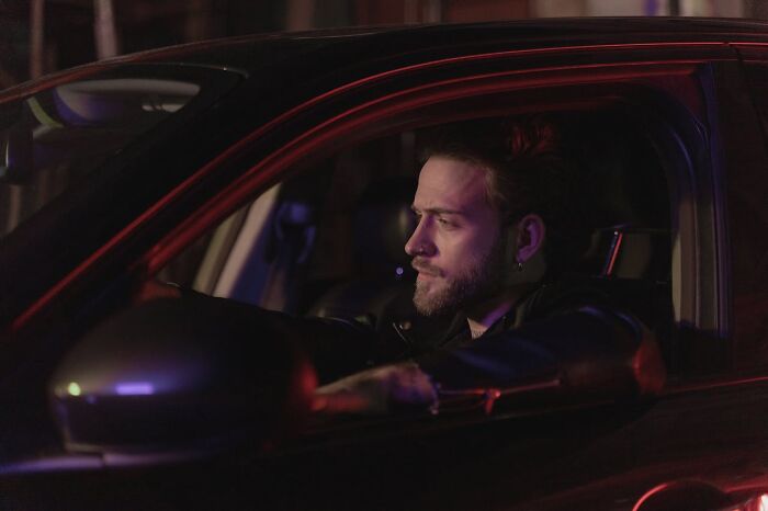Man in a car looking serious at night, reflecting on moments that made him say he was definitely dead but survived.