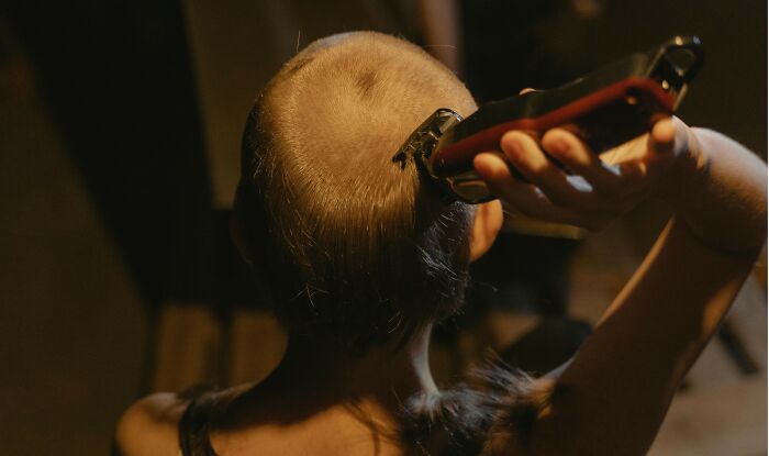 Person shaving head with electric clippers, illustrating nasty things exes did that left partners shocked and grossed out.