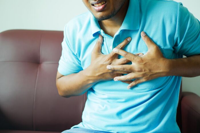 Man in a blue shirt clutching his chest in pain, illustrating a patient with a rare disease encounter.