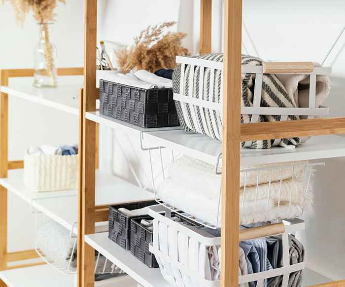 Organized shelves with baskets and folded fabrics reflecting habits people who used to be poor maintain consistently.
