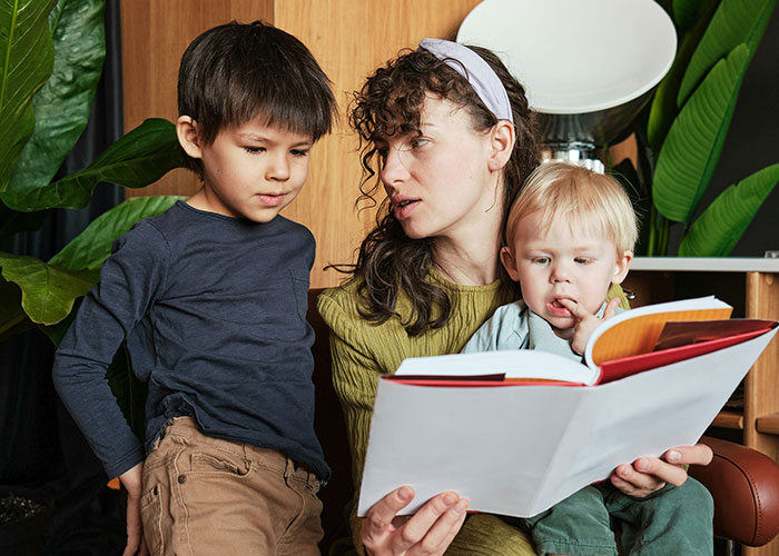 Woman manipulating children’s attention while reading a book, illustrating hilarious job descriptions concept.