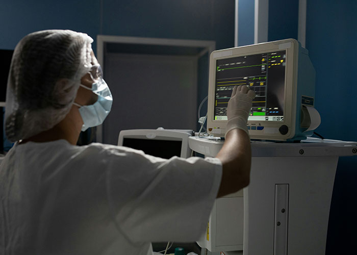 Healthcare worker in protective gear manipulating medical equipment, illustrating hilarious job descriptions with product interaction.