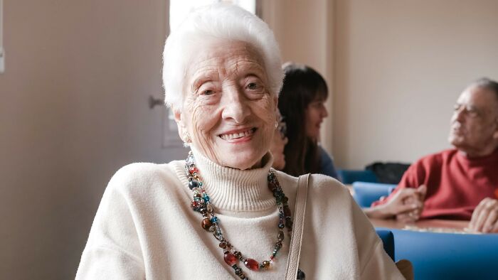 Elderly woman smiling in a cozy room, representing patients who defied medical odds according to doctors.