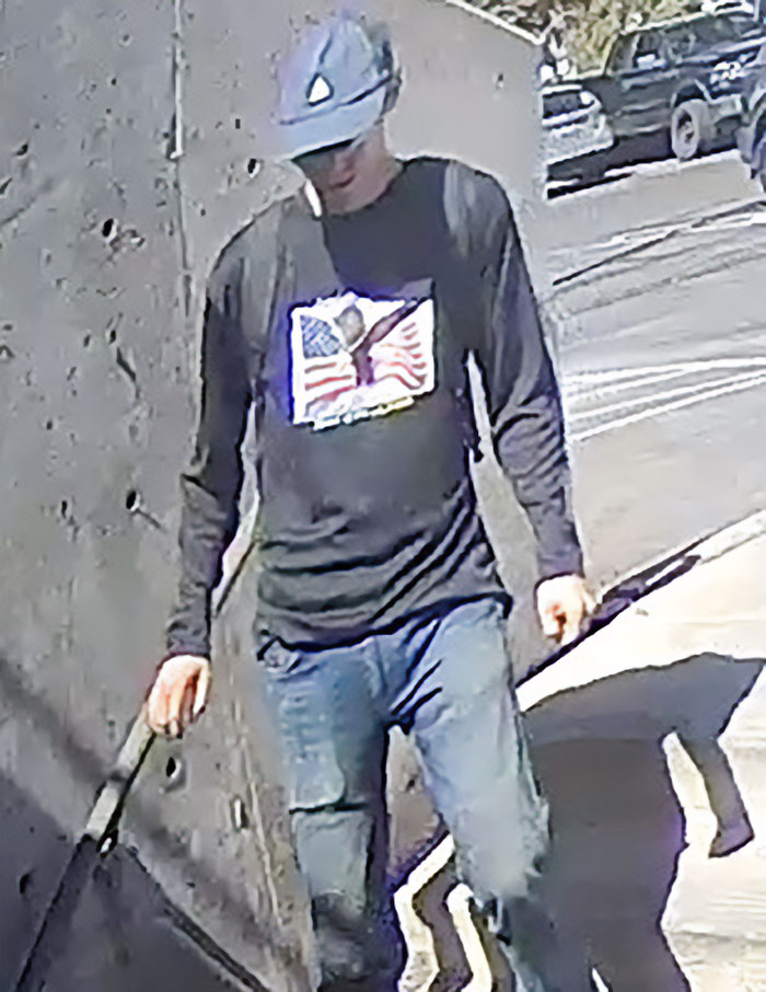 Man in a cap and flag shirt captured in CCTV footage showing the daring escape of the main suspect in fatal attack.