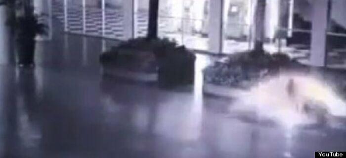 Blurry indoor scene showing a bright explosion or light flare, part of strange and unexplained histories captured on camera