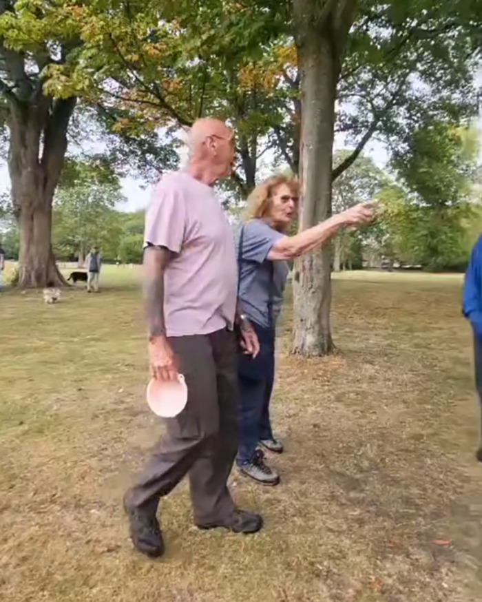 Two older men argue in a UK park with trees and grass visible, linked to racial assault against Filipino nurse outrage. Two older men argue in a UK park with trees and grass visible, linked to racial assault against Filipino nurse outrage.