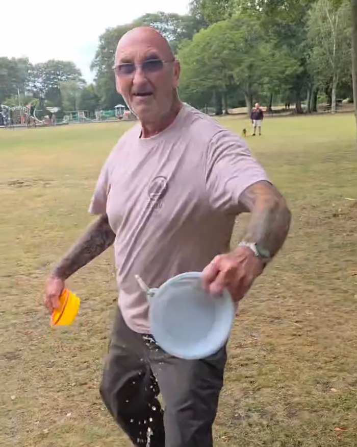Man in a UK park with tattoos throwing water from a container, related to racial assault against Filipino nurse outrage. Man in a UK park with tattoos throwing water from a container, related to racial assault against Filipino nurse outrage.