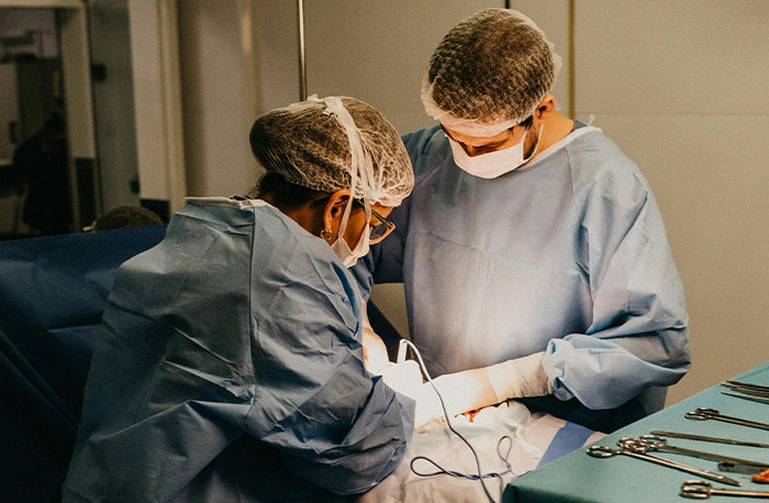 Two doctors wearing surgical gowns and masks performing a medical procedure illustrating accurate diagnoses.