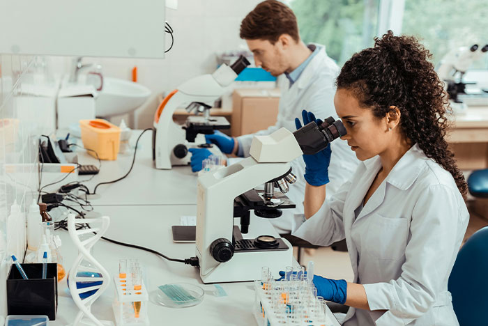 Two doctors examining samples under microscopes in a lab, illustrating accurate diagnoses from House M.D.