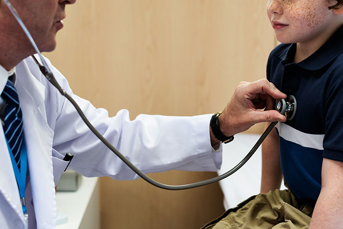 Doctor using stethoscope to examine a child’s chest, illustrating accurate and least accurate diagnoses from House M.D.