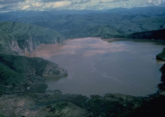 A dark, eerie lake surrounded by hills, evoking a chilling atmosphere for scary real-life stories.