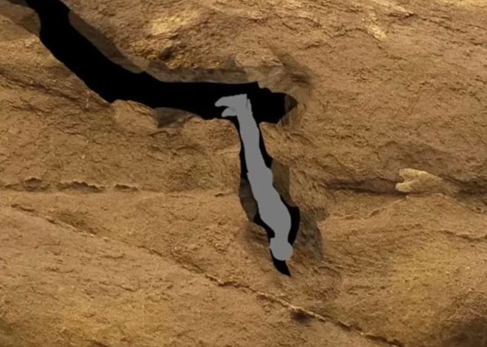 Silhouette of a person trapped headfirst in a narrow rock crevice, illustrating scary real-life stories.