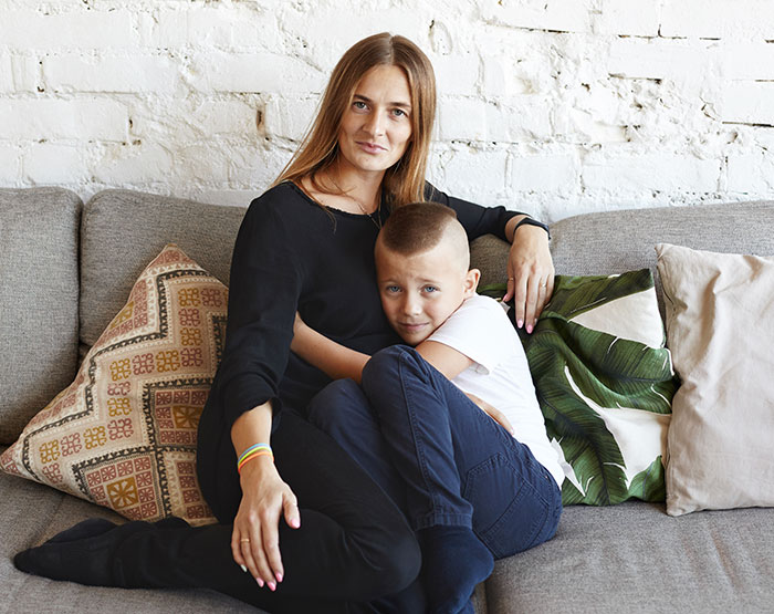 Mom and young boy sitting closely on a couch, illustrating a story about a mom giving her baby up and wanting it back.