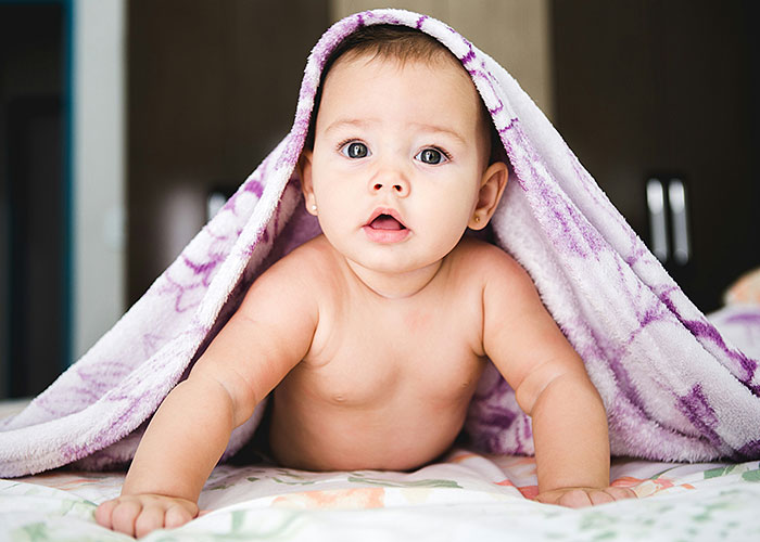 Baby lying under a purple blanket, representing a man wanting to name his baby after his first girlfriend, upsetting his wife. Baby lying under a purple blanket, representing a man wanting to name his baby after his first girlfriend, upsetting his wife.
