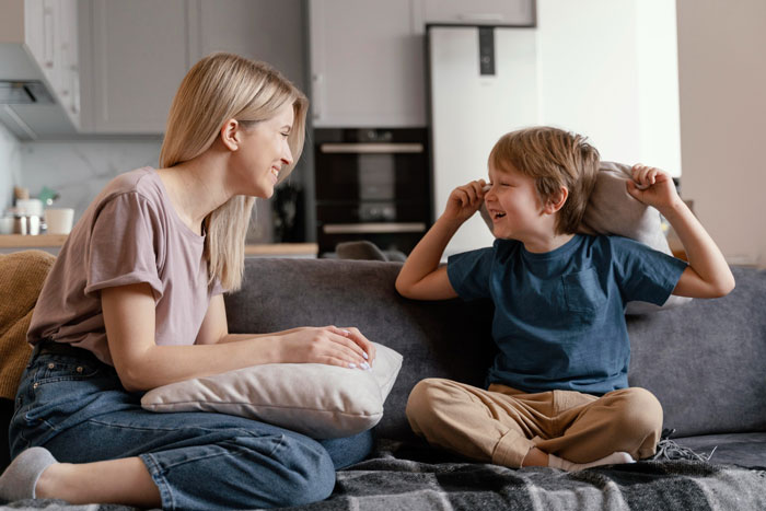 Woman and child interacting happily on a couch, illustrating family dynamics related to refusing to look after brother’s children. Woman and child interacting happily on a couch, illustrating family dynamics related to refusing to look after brother’s children.