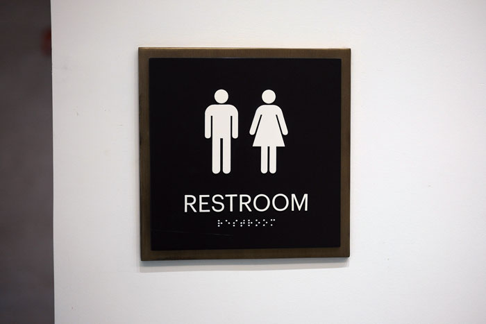 Restroom sign showing male and female symbols indicating a shared or unisex bathroom entrance.