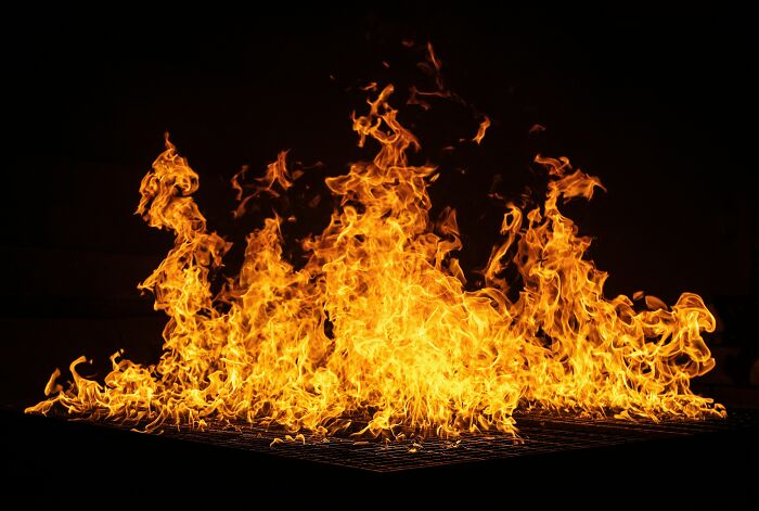 Bright orange and yellow flames engulfing a dark background, illustrating a shocking event causing loss of savings.