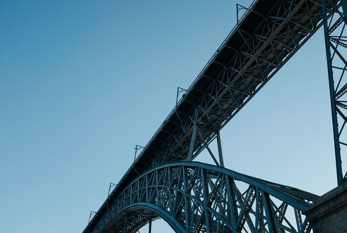 Steel bridge structure with clear blue sky, symbolizing strength and resilience after dealing with school bullies.