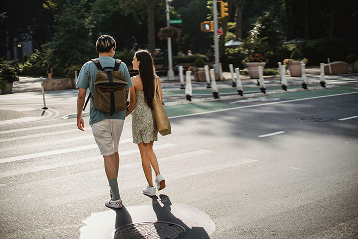 Couple walking across a city street holding hands, illustrating maddening and illogical reasons men got upset at women.