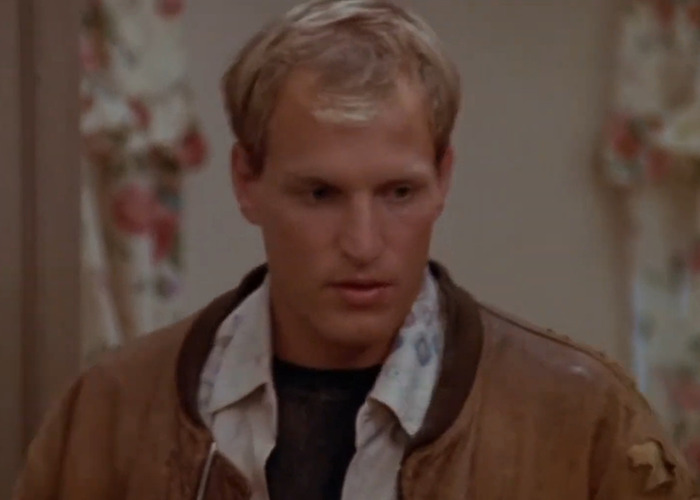 Woody Harrelson in a brown jacket and patterned shirt, captured during filming an intimate scene with Rosie Perez.