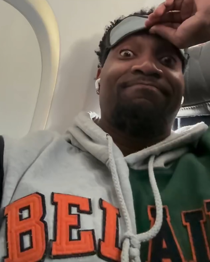 Entitled passenger wearing headphones inside airplane reacting after being kicked off flight by attendant Entitled passenger wearing headphones inside airplane reacting after being kicked off flight by attendant