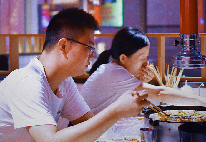 Two people eating at a restaurant, illustrating unintended consequences and how people blew up someone else's life.